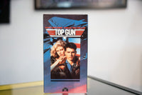 Top Gun VHS blue sleeve with F-14 Tomcat jets Tom Cruise leather bomber jacket Kelly McGillis red TOP GUN logo gold star Paramount