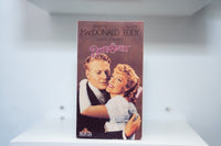VHS Bitter Sweet rose-toned cover Nelson Eddy Jeanette MacDonald romantic embrace Bitter Sweet pink script text Noel Coward MGM/UA