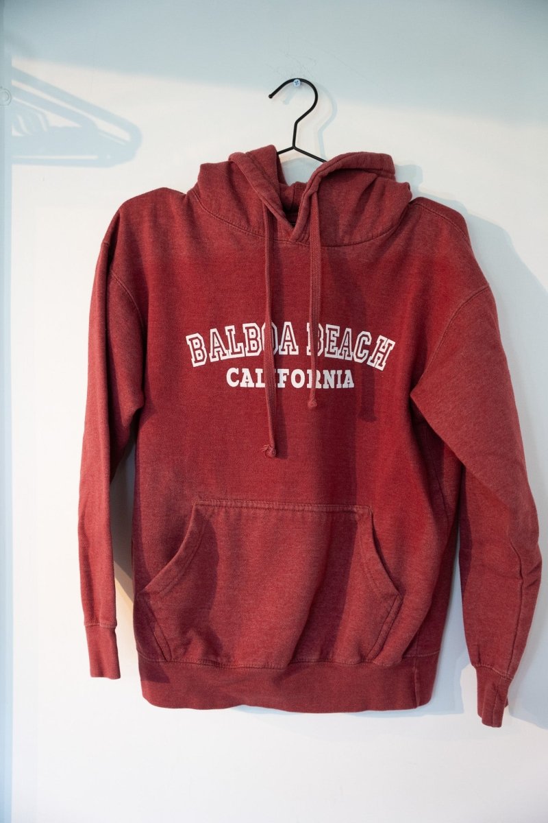 Washed faded red maroon vintage Balboa Beach California pullover hoodie with white outlined BALBOA BEACH collegiate text drawstring hood size Medium
