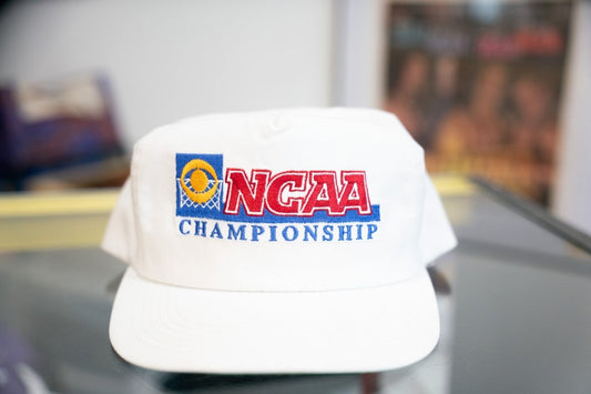 White vintage CBS Sports NCAA Championship snapback hat with red NCAA lettering, blue Championship text, and gold basketball hoop logo