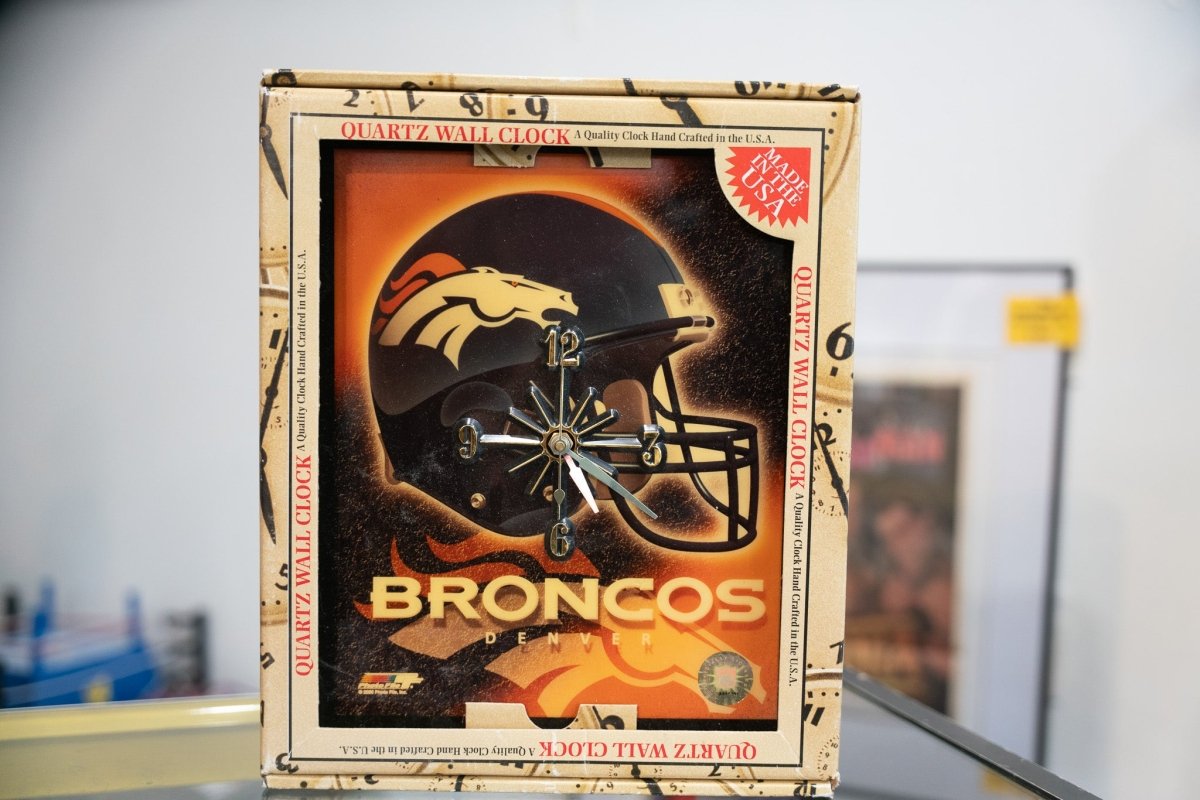 Vintage Denver Broncos quartz wall clock in original box featuring Broncos helmet on black and orange gradient background