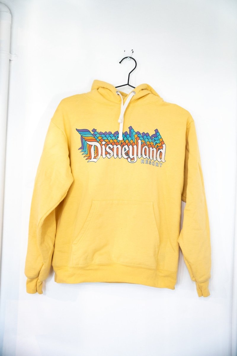 Golden yellow vintage Disneyland Resort pullover hoodie with white Old English Disneyland text and rainbow geometric pattern fill size Small