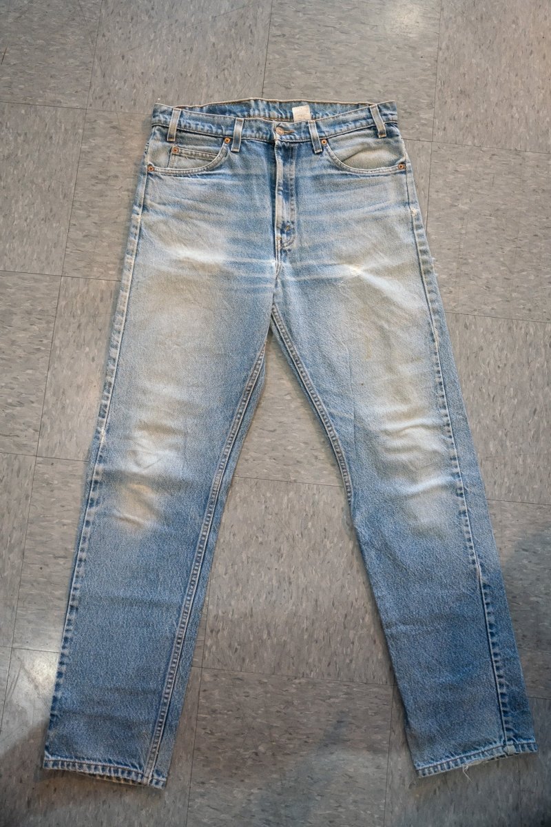 Light wash vintage Levi's 505 orange tab denim jeans with heavy natural fading at thighs knees copper rivets straight leg W34 L33