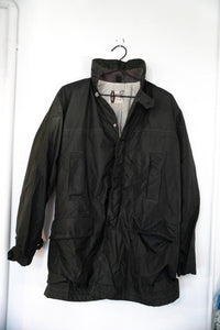 Dark olive green vintage Penneys nylon field jacket with standing collar snap storm flap large flap pockets and gray lining size 40