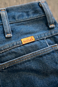Wrangler Rustler denim jeans, size W32 L32, featuring classic five-pocket construction with visible stitching and bronze hardware on denim fabric