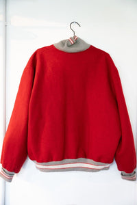 UNLV wool letterman jacket in burgundy and gold, size XL, with chenille patches and leather sleeves, displayed on a hanger