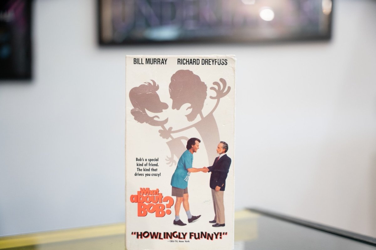 What About Bob VHS cream sleeve with Bill Murray blue shirt shaking hands Richard Dreyfuss suit chaotic shadow orange title Howlingly Funny quote