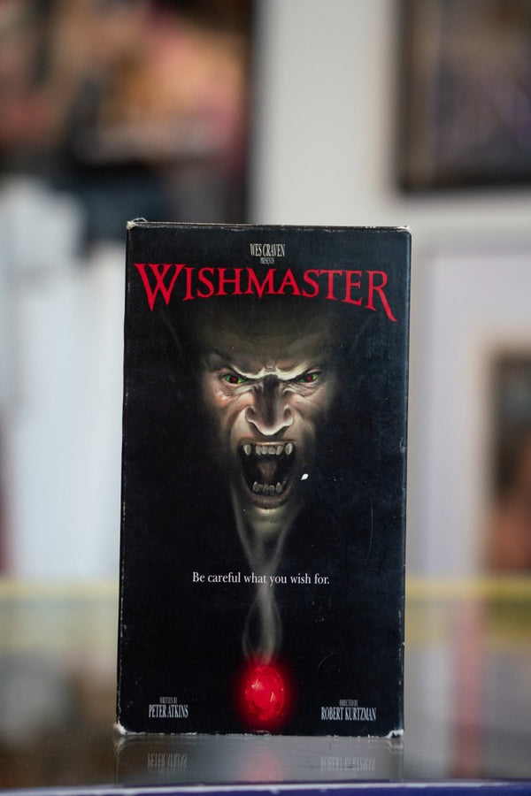 Wishmaster VHS tape with demonic Djinn face with green eyes emerging from darkness above glowing red jewel with red Gothic title