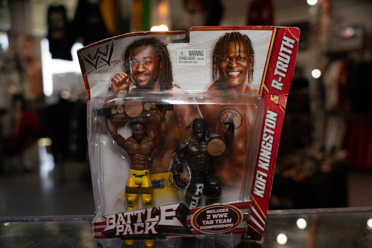 WWE Battle Pack figures showing Kofi Kingston and R-Truth wrestling action figures with printed details and articulated joints, packaged together