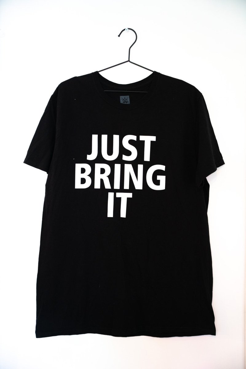 Black WWE The Rock Just Bring It tee with large white JUST BRING IT block lettering centered on chest WWE tag