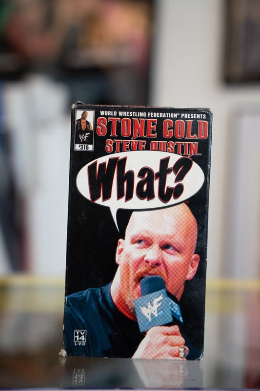 WWF Stone Cold Steve Austin What VHS tape with Austin close-up on mic with What speech bubble on black cover with red title text