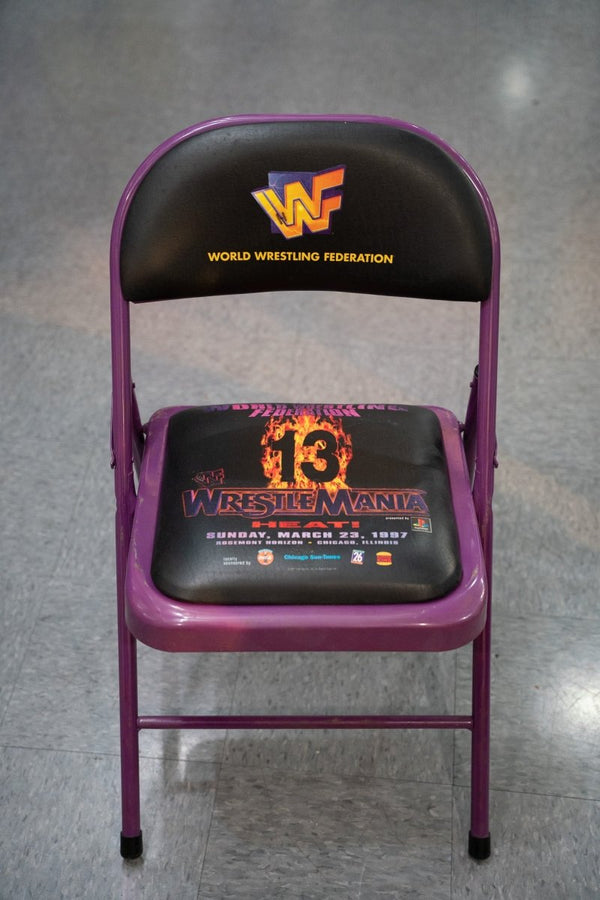 WWF WrestleMania 13 original ringside folding chair with purple metal frame black seat and flaming 13 HEAT event branding from March 1997