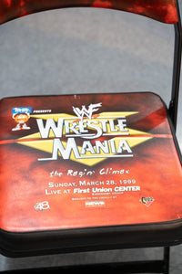 WWF WrestleMania 15 black metal folding chair with white logo print, circa 1999 event merchandise