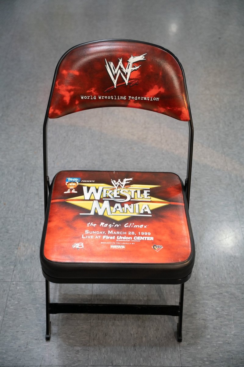 WWF WrestleMania XV original ringside folding chair with red flame graphics WWF logo and Ragin Climax event branding from March 1999